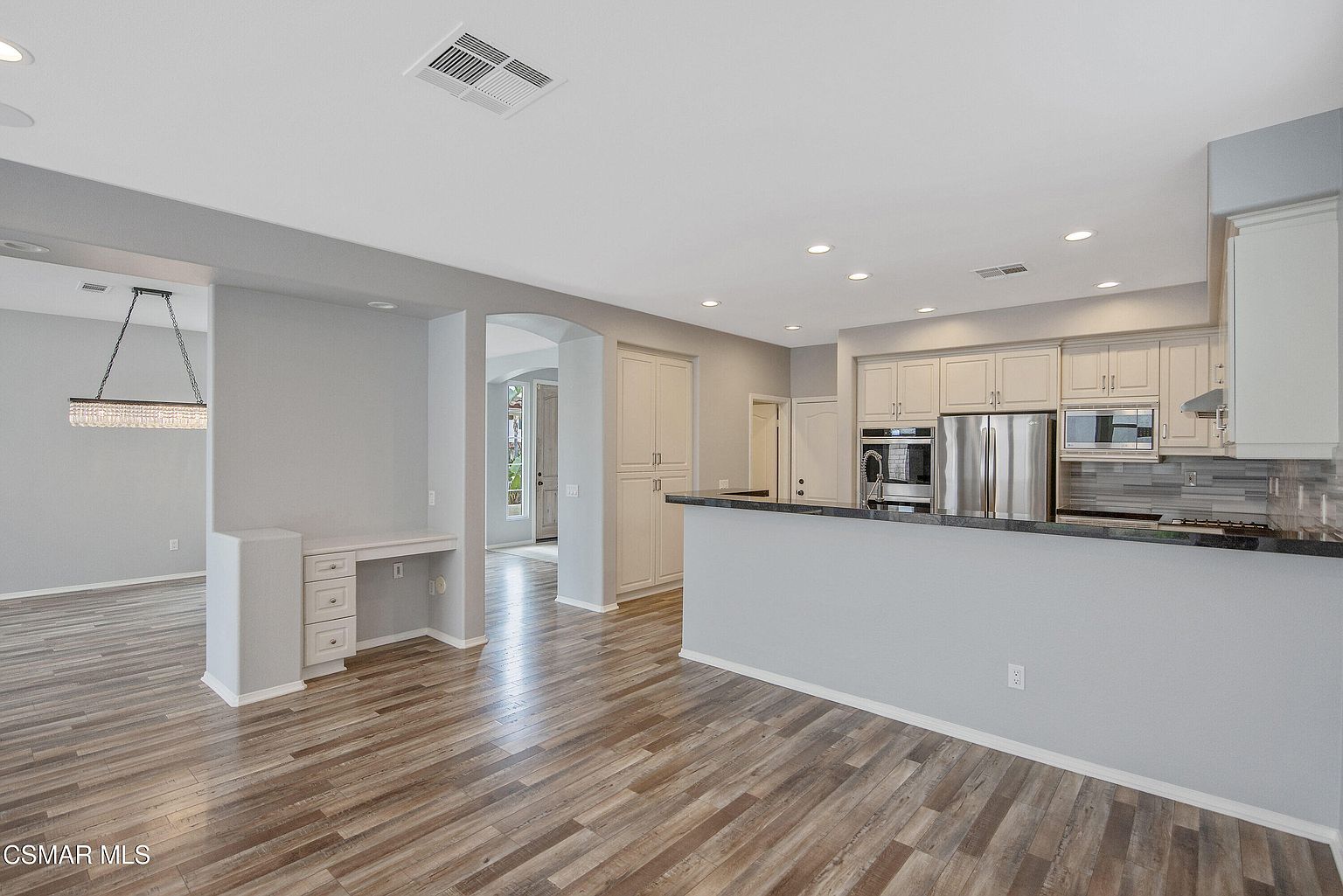 Refreshed kitchen with white cabinetry, granite countertops, and stainless appliances.