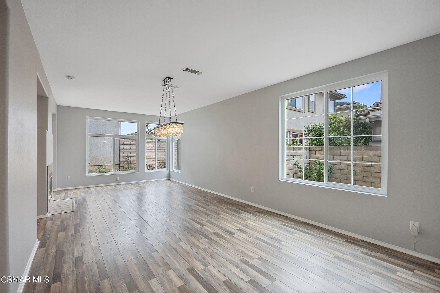 Family room with abundant natural light, built-in shelving, and oversized windows.