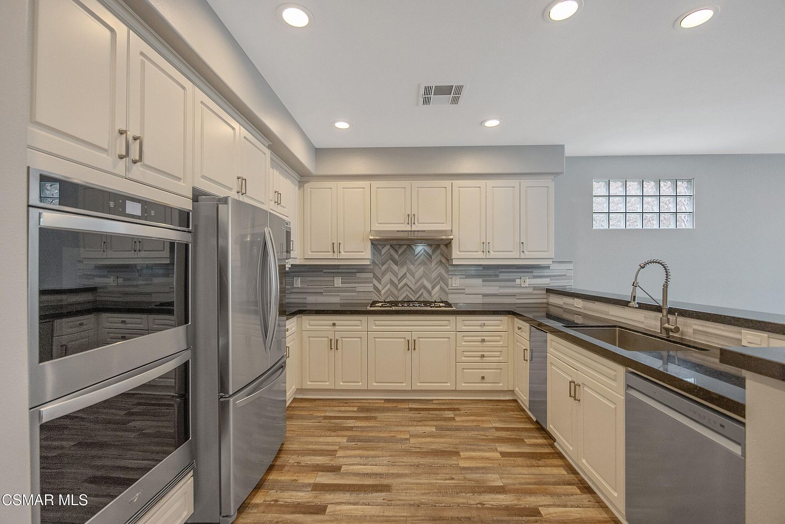 Kitchen pass-through with desk nook and breakfast bar.