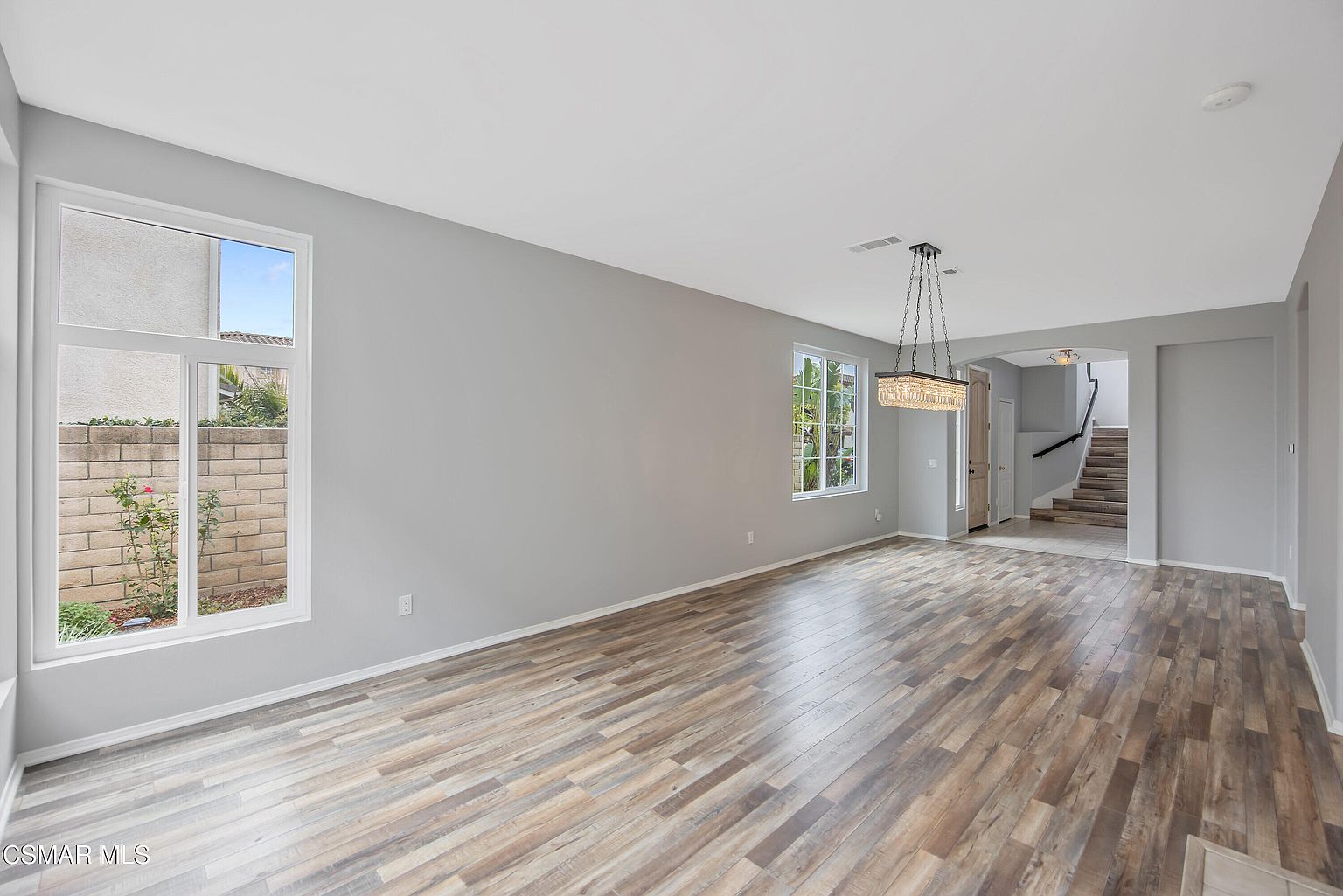 Stair landing with twin square windows and pendant lighting.