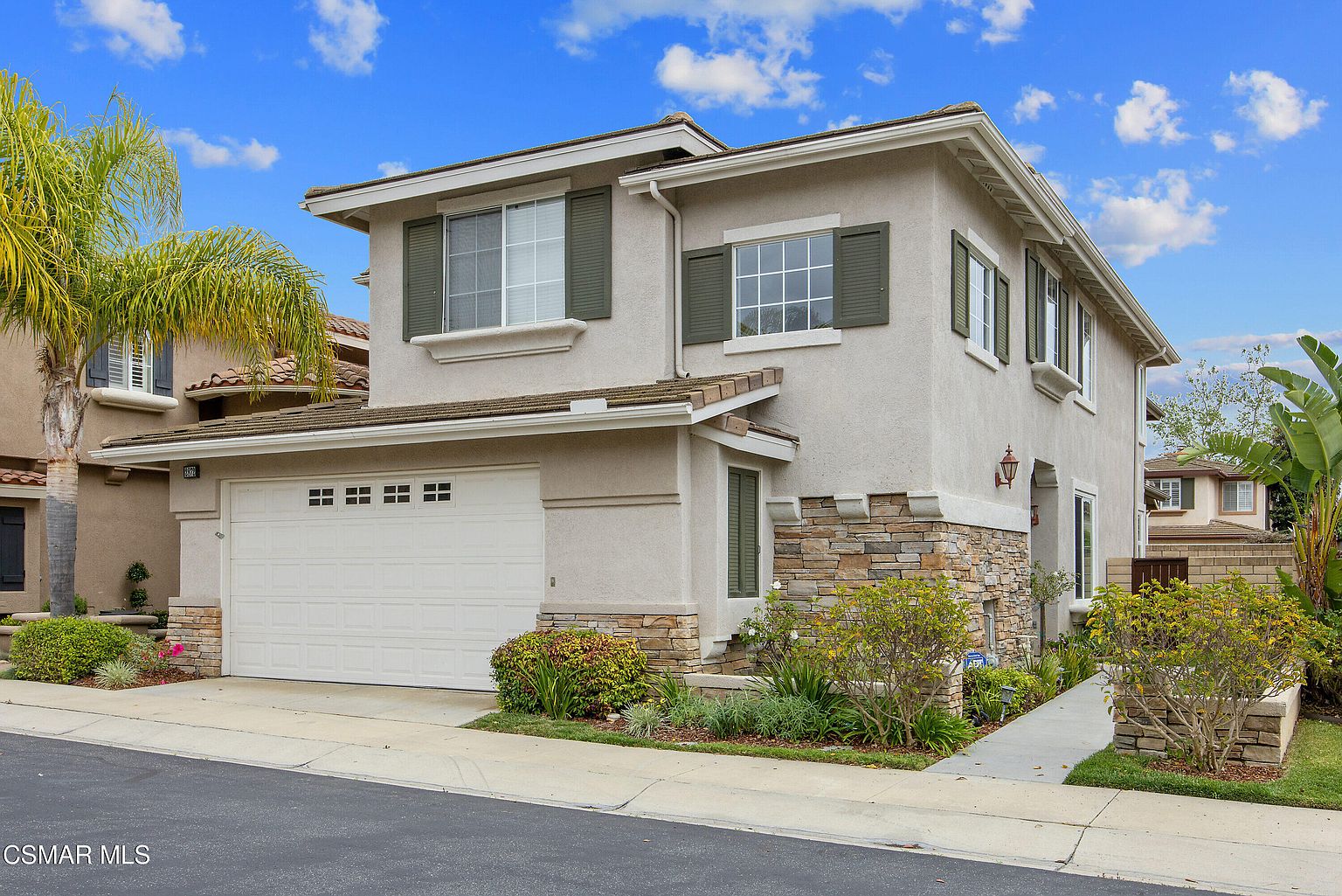 Front elevation of 2872 La Plata Drive, a two-story California stucco residence at The Fairways at Sterling Hills with stone-base architecture, manicured landscaping, and a clear blue sky.